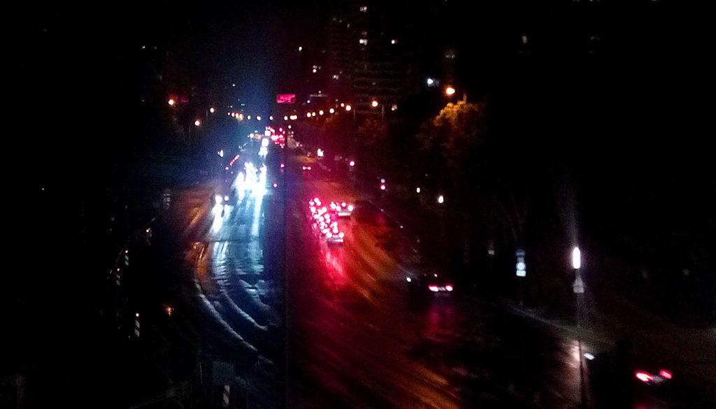 Iyä-Berliinin puolella iso autotie, josta näkyvät vain katuvalot ja autojen valaisemat kohdat yöllä pimeässä.